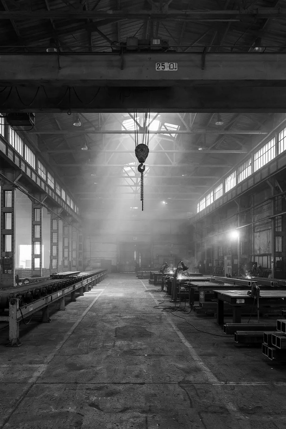 Steel fabrication hall with an overhead crane hook and welding benches